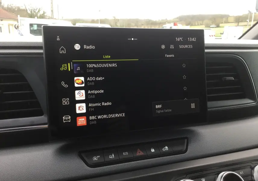 Écran tactile central du tableau de bord du Renault Master blanc, affichant les stations radio DAB en intérieur.