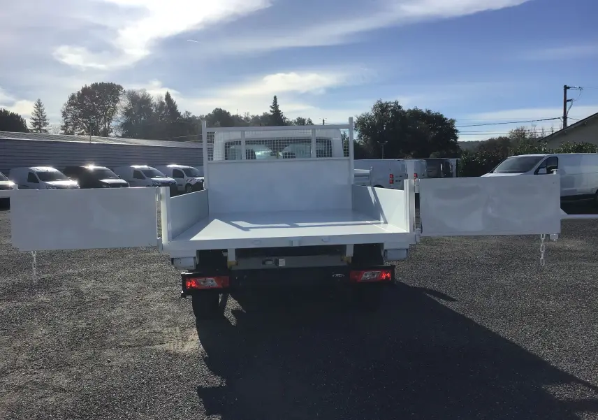 Vue arrière d'un Ford Transit Chassis Cabine blanc avec benne ouverte et portes latérales déployées.
