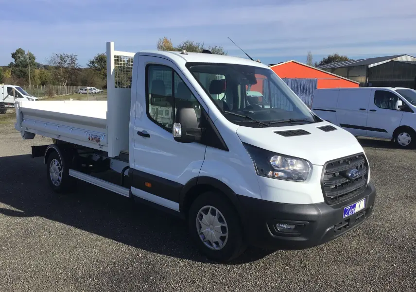 Ford Transit Chassis cabine blanc vu en 3/4 avant droit avec benne et bras polybenne sur parking extérieur.