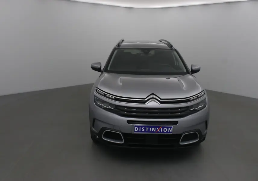 Citroën C5 Aircross gris Artense vue de face dans un studio, avec calandre distinctive et logo double chevron visible.