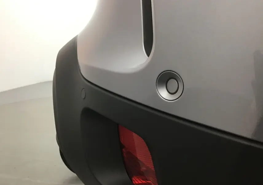 Détail du pare-chocs arrière gris Artense du Citroën C5 Aircross avec capteur de recul et feu rouge intégré.