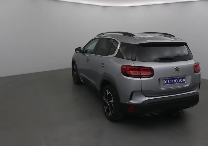 Vue 3/4 arrière droite du Citroën C5 Aircross gris Artense avec feux arrière LED et toit noir contrasté.