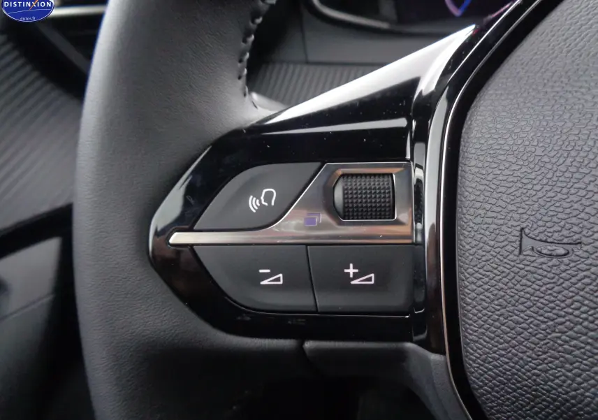 Gros plan sur les commandes vocales et volume au volant d'une Peugeot 2008 bleu Vertigo Metal, finition Allure 2023.