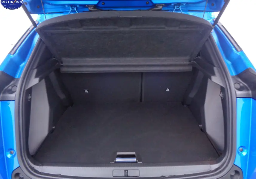 Coffre ouvert vu de l'arrière d'une Peugeot 2008 2023 bleu Vertigo Metal, espace de chargement vide et propre.