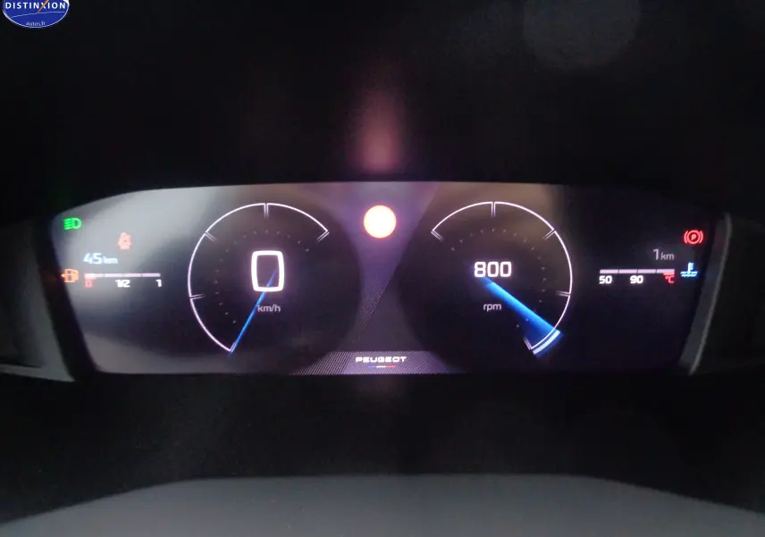 Tableau de bord numérique du Peugeot 2008 2023 affichant vitesse à 0 km/h et régime moteur à 800 rpm, éclairage LED bleu.