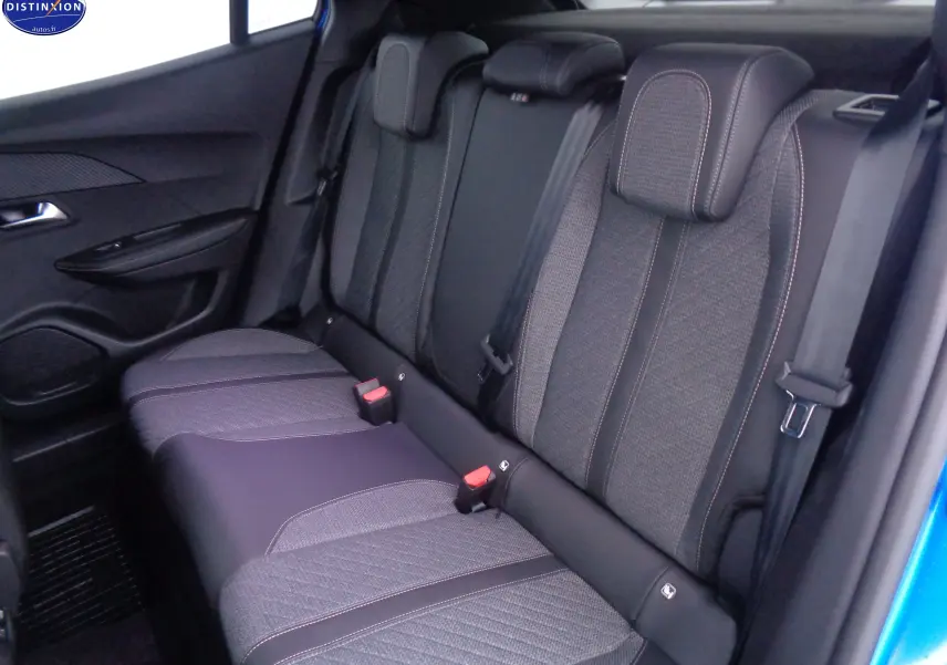 Vue intérieure arrière des sièges en tissu gris et cuir noir du Peugeot 2008 bleu Vertigo 2023, avec ceintures visibles.