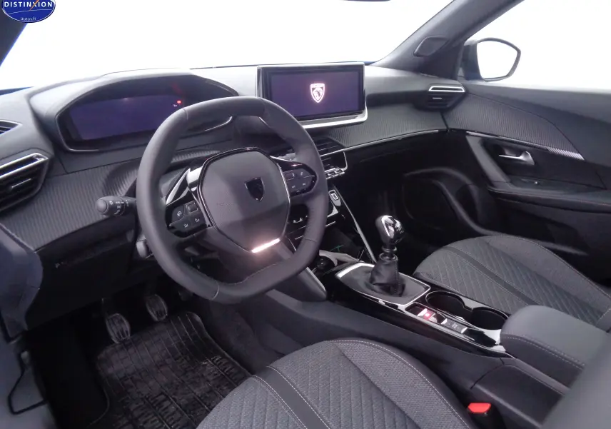Intérieur avant du Peugeot 2008 2023 avec tableau de bord moderne, volant compact et console centrale avec boîte manuelle.