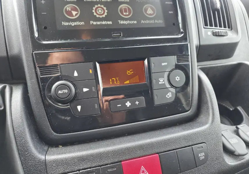 Gros plan sur la console centrale noire de l'Opel Movano Fourgon 2022, affichant la climatisation et l'écran tactile.