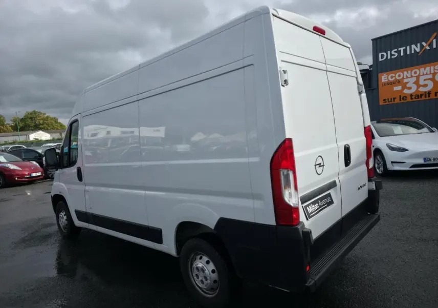 Vue 3/4 arrière droite d'un Opel Movano Fourgon blanc avec portes arrière battantes et panneau latéral lisse.