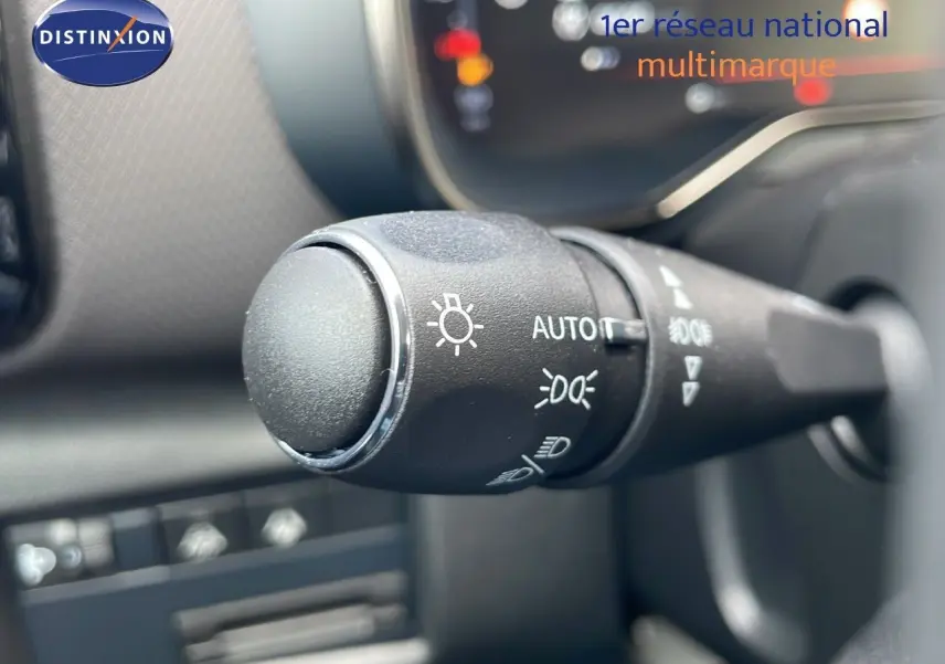 Gros plan sur la commande des phares du Citroën C5 Aircross 2025, soulignant les réglages automatiques et manuels.