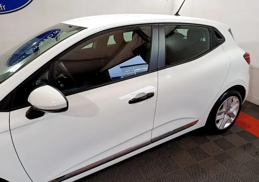 Profil droit d'une Renault Clio Business blanche, mettant en valeur la ligne fluide et les jantes alliage.