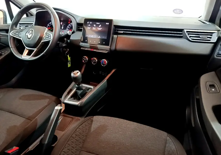 Intérieur avant de la Renault Clio Business 2021, vue côté conducteur, tableau de bord noir avec écran tactile et levier de vitesse manuel.