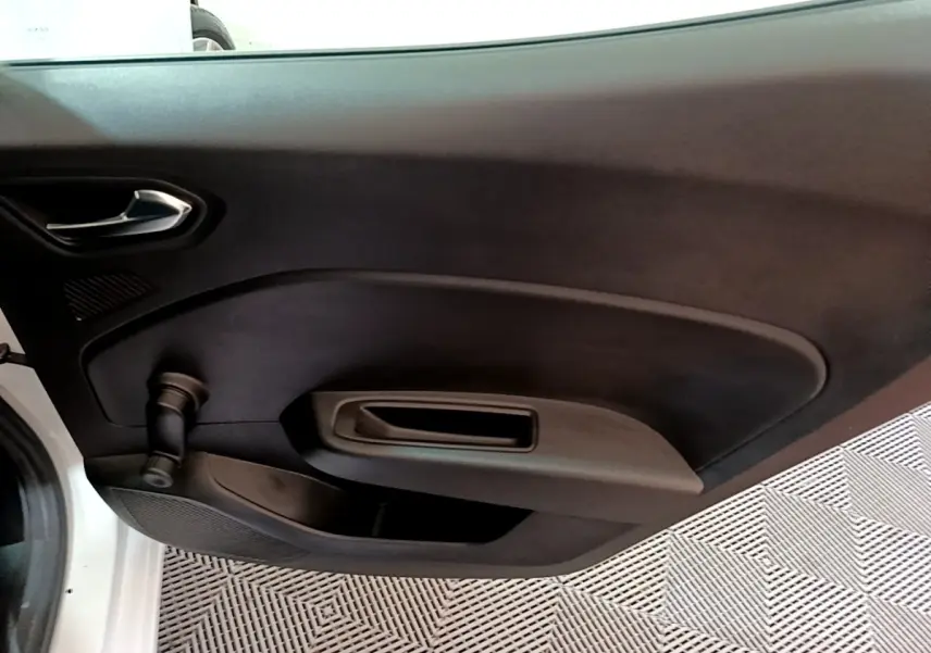 Vue intérieure de la porte avant gauche noire d'une Renault Clio blanche avec poignée et manivelle de vitre.