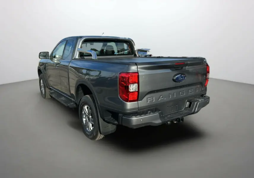 Vue 3/4 arrière droite du Ford Ranger noir shadow avec rideau de benne et arceaux inox visibles.