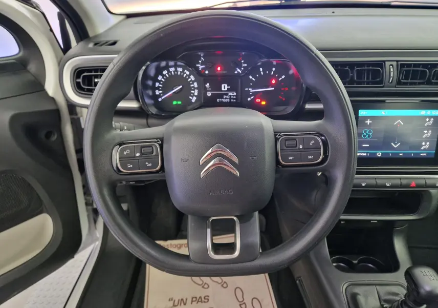 Vue centrée sur le volant noir de la Citroën C3 Société blanche, avec tableau de bord et écran tactile visibles.