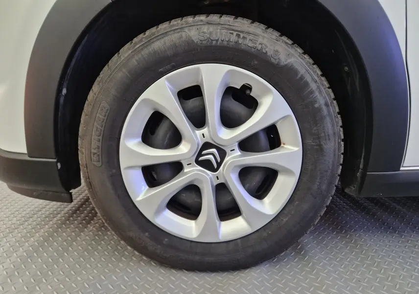 Gros plan sur la roue avant gauche blanche d'une Citroën C3 Société 2019 avec enjoliveur et logo Citroën visible.
