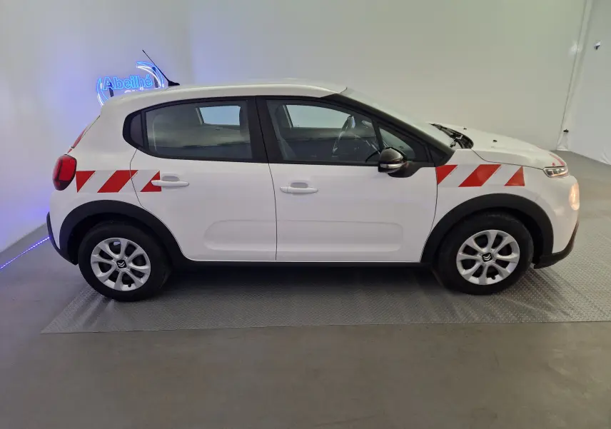 Profil droit d'une Citroën C3 Société blanche 2019 avec bandes rouges diagonales sur ailes avant et arrière.