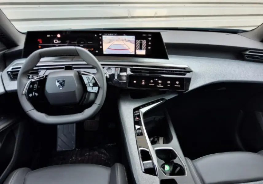 Vue intérieure avant du Peugeot 3008 2026, tableau de bord moderne avec écran incurvé et volant compact noir.