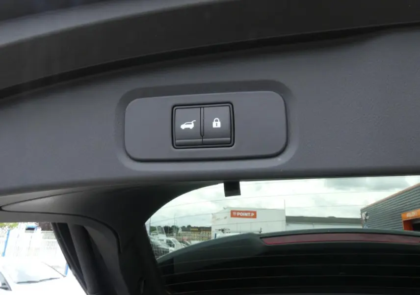 Détail du bouton de hayon électrique et verrouillage sur le bord intérieur du coffre du Nissan Qashqai gris métallisé 2025.