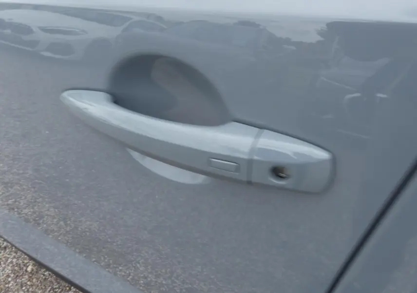 Poignée de porte côté droit gris métallisé du Nissan Qashqai 1.5 e-Power 2025 avec serrure visible.