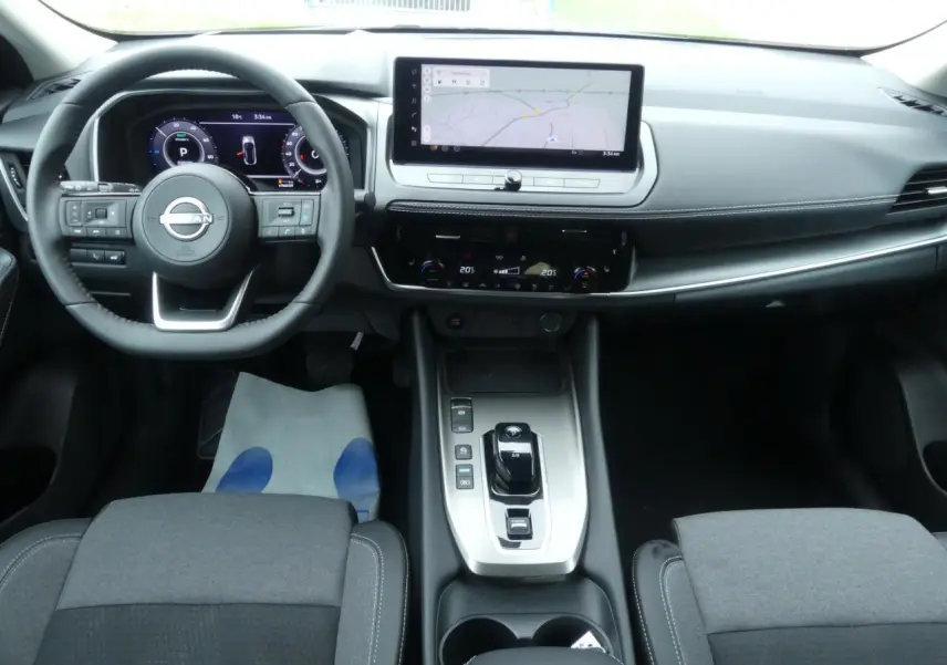 Vue intérieure avant du Nissan Qashqai 1.5 e-Power 2025, tableau de bord moderne avec écran tactile et volant cuir noir.
