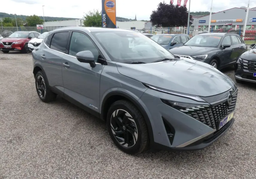Nissan Qashqai 1.5 e-Power gris métallisé en 3/4 avant droit avec calandre distinctive et jantes alliage.