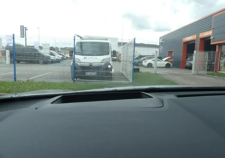 Vue intérieure du tableau de bord du Nissan Qashqai gris métallisé, affichage tête haute visible sur le pare-brise.