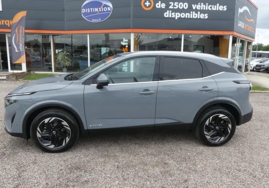 Vue latérale gauche du Nissan Qashqai 1.5 e-Power gris métallisé avec jantes alliage et vitres teintées.