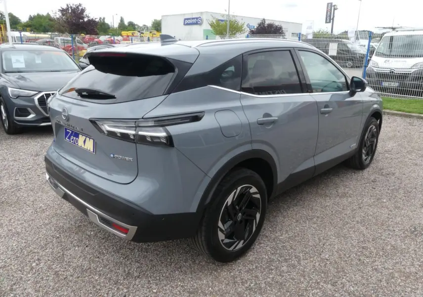 Vue 3/4 arrière droite du Nissan Qashqai 1.5 e-Power gris métallisé avec toit noir et jantes alliage 18 pouces.