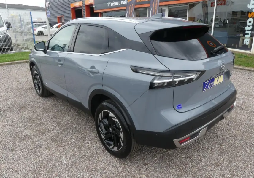 Vue 3/4 arrière droite du Nissan Qashqai 1.5 e-Power gris métallisé avec vitres teintées et jantes alliage noires.