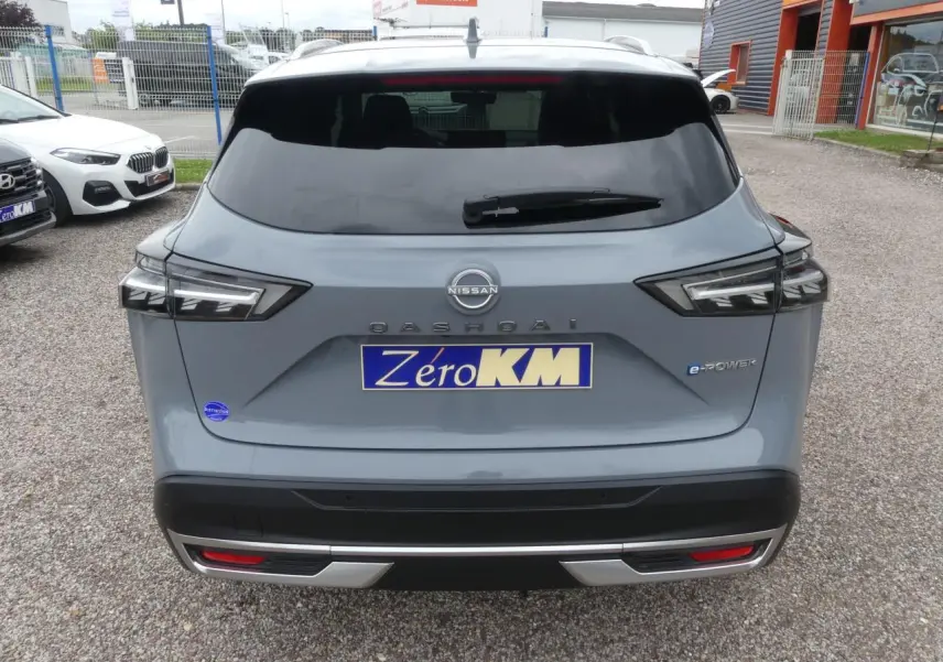 Vue arrière d'un Nissan Qashqai gris métallisé e-Power avec feux LED et logo distinctif sur hayon fermé.