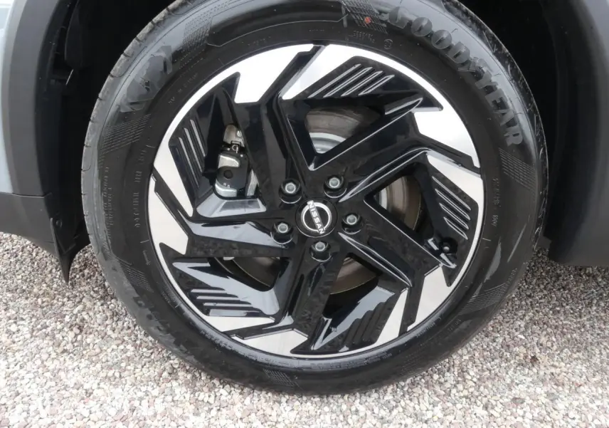 Gros plan sur la jante alliage bicolore noir et argentée d'un Nissan Qashqai gris métallisé côté avant droit.