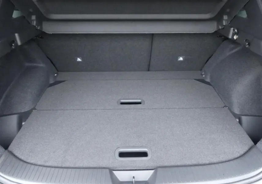 Coffre spacieux du Nissan Qashqai 1.5 e-Power gris métallisé avec plancher modulable et crochets de fixation visibles