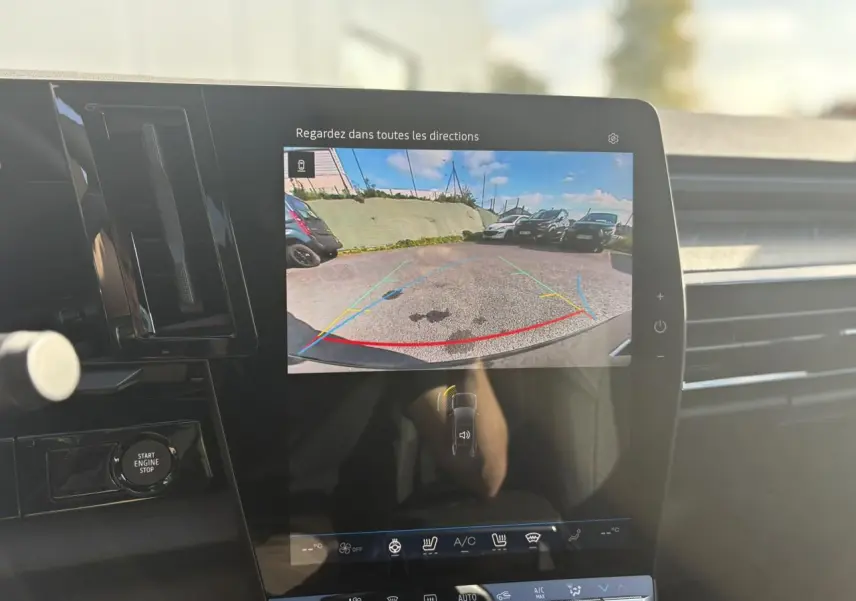 Écran central du Renault Rafale E-Tech affichant la caméra de recul avec vue arrière du parking, intérieur noir moderne.