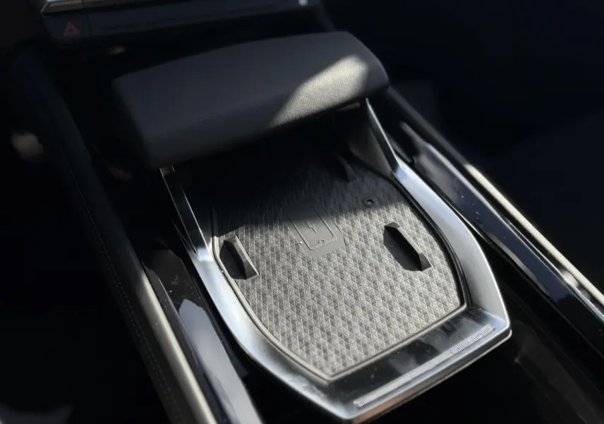 Plateau de recharge sans fil gris et noir au centre de la console de la Renault Rafale E-Tech Full Hybrid 2025.