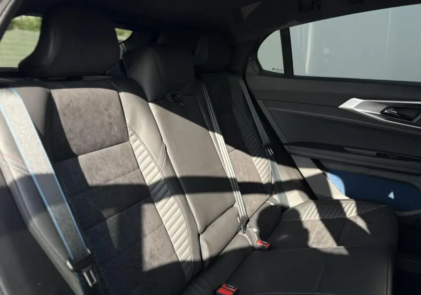 Banquette arrière en cuir et textile gris avec surpiqûres bleu, blanc, rouge dans Renault Rafale E-Tech 2025, vue côté droit.