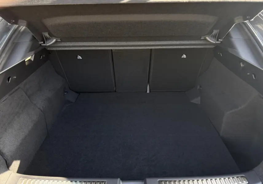 Coffre ouvert vu de l'arrière d'une Renault Rafale gris schiste, espace de chargement vide et tapis noir.