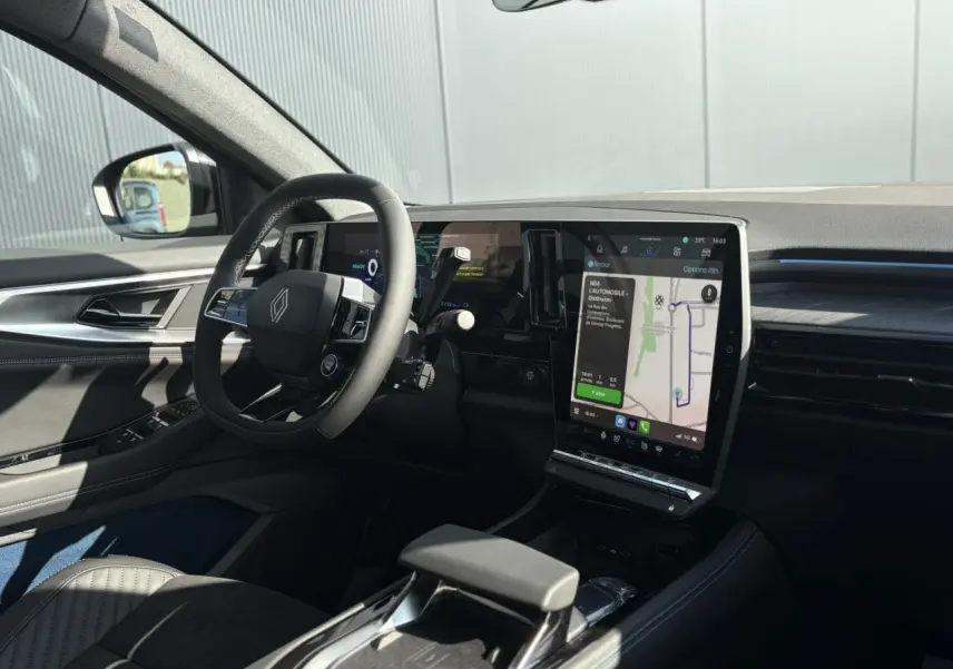 Intérieur avant gauche de la Renault Rafale E-Tech gris schiste, volant Alcantara et écran tactile vertical avec navigation.