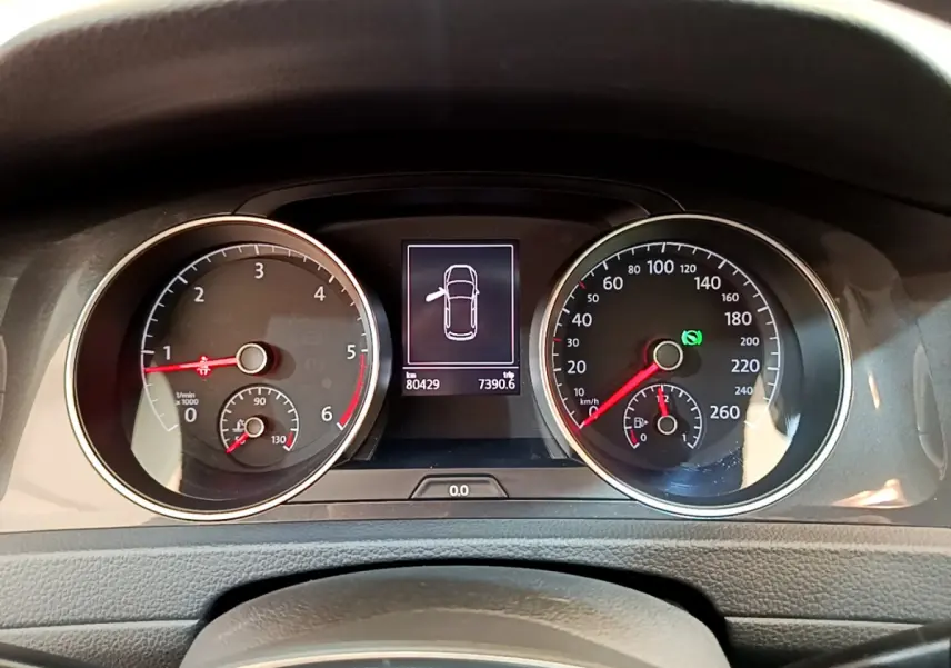 Tableau de bord de Volkswagen Golf gris clair 2019, affichage digital au centre avec compteurs ronds analogiques.