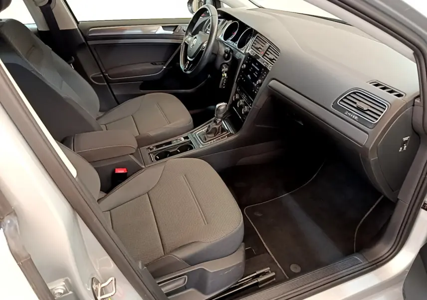 Intérieur avant droit de la Volkswagen Golf 1.6 TDI 2019, sièges gris foncé et tableau de bord avec écran tactile.