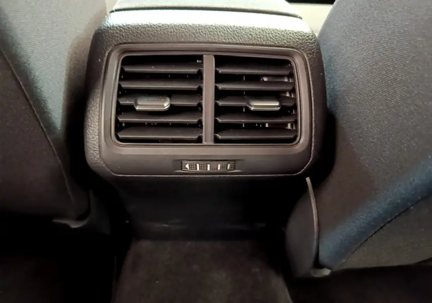 Grille d'aération arrière noire vue de face entre les sièges avant d'une Volkswagen Golf gris clair 2019.