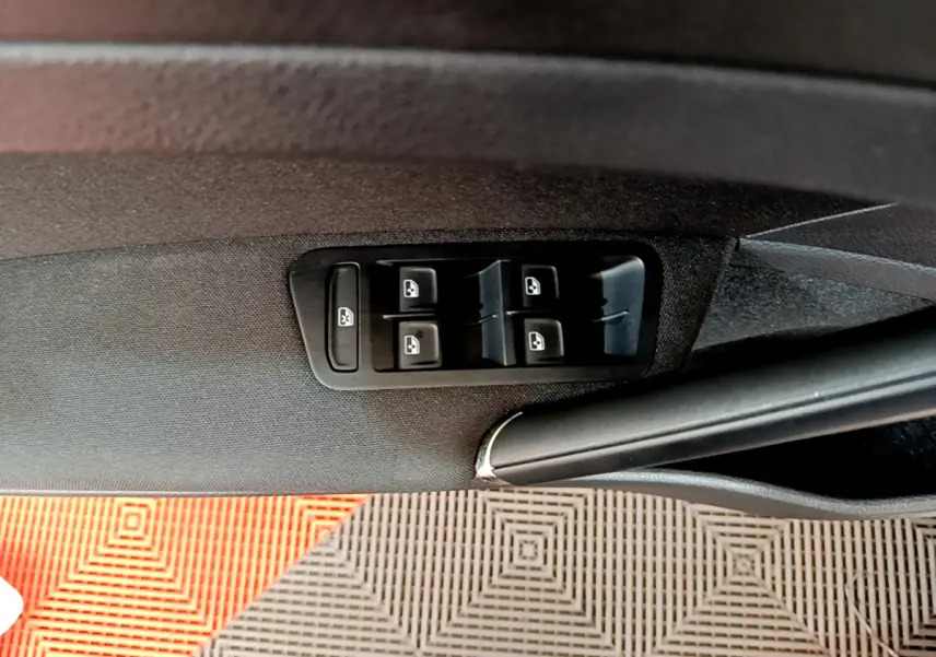 Panneau de commandes des vitres électriques côté conducteur dans une Volkswagen Golf gris clair 2019, intérieur noir.