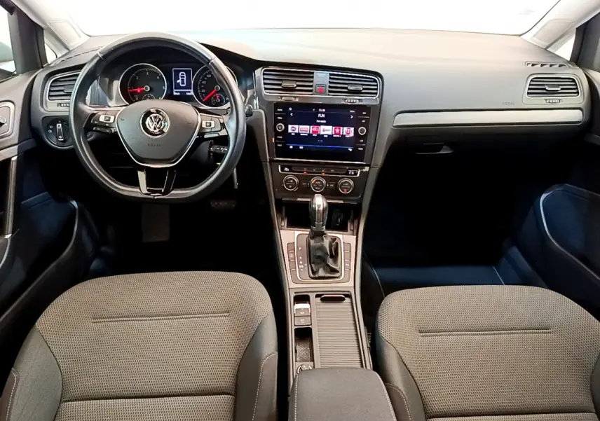 Vue intérieure avant de la Volkswagen Golf 1.6 TDI 2019, tableau de bord avec écran tactile et volant multifonctions noir.