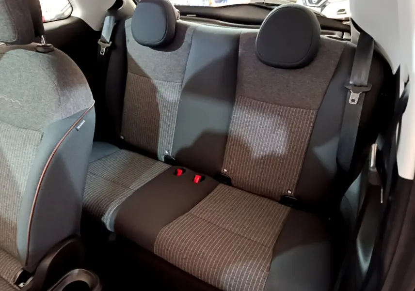 Vue intérieure arrière droite des sièges gris à motifs rayés du Fiat 500 électrique blanc 42kWh Icône 2022.