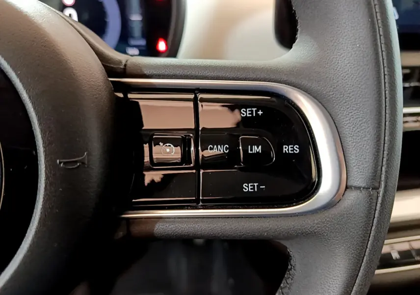 Gros plan sur les commandes du régulateur de vitesse au volant cuir noir d'une Fiat 500 blanche électrique 2022.