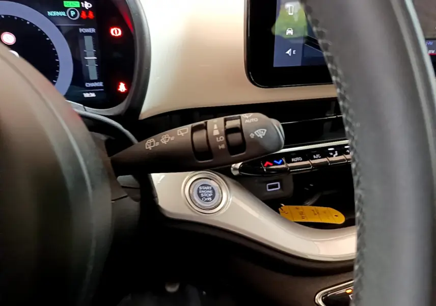 Détail intérieur du tableau de bord blanc de la Fiat 500 électrique 2022, avec bouton start/stop et commandes au volant visibles.