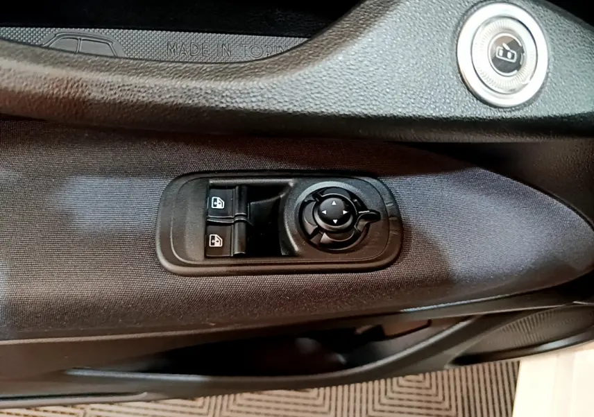 Détail des commandes de lève-vitres et rétroviseurs sur la porte côté gauche d'une Fiat 500 blanche Icône 2022 électrique.