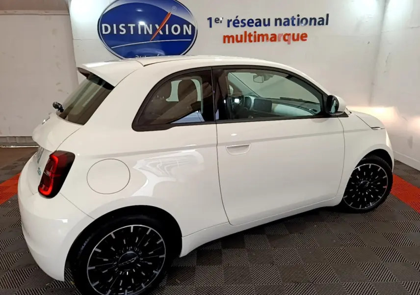 Vue côté droit d'une FIAT 500 électrique blanche version 42kWh Icône avec jantes noires stylisées.