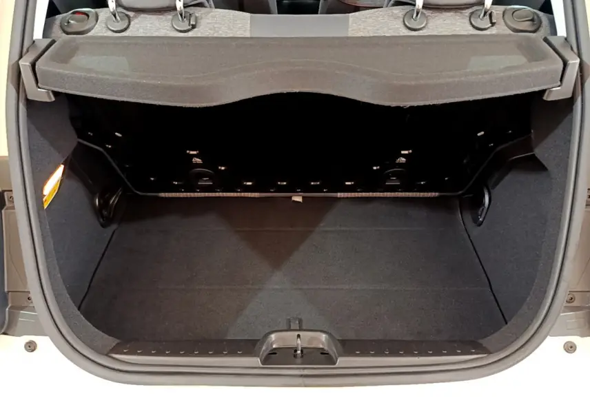 Coffre ouvert vu de l'arrière d'une FIAT 500 blanche électrique, montrant l'espace de chargement et la tablette de séparation.