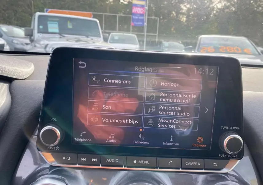 Écran tactile central du Nissan Juke 2024 affichant le menu réglages avec options de connexion et audio.
